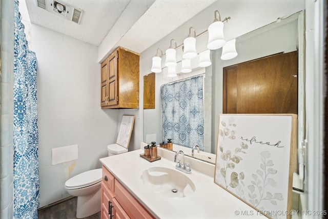 full bath featuring visible vents, toilet, a shower with curtain, a textured ceiling, and vanity