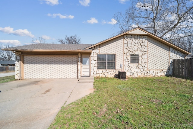 mid-century home with driveway, stone siding, fence, roof with shingles, and a front yard