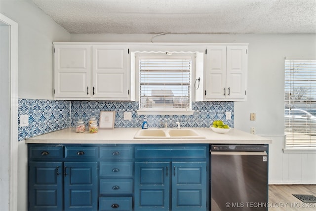 kitchen with dishwasher, white cabinets, blue cabinets, and a sink