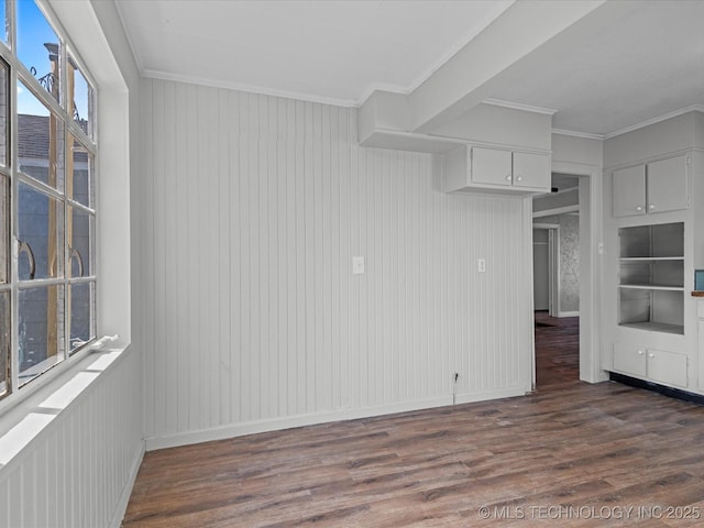 unfurnished room with baseboards, ornamental molding, and dark wood-style flooring