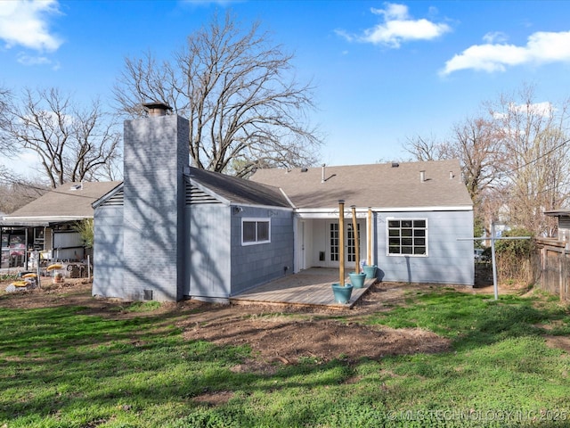 rear view of house featuring fence, a yard, french doors, a chimney, and a patio area