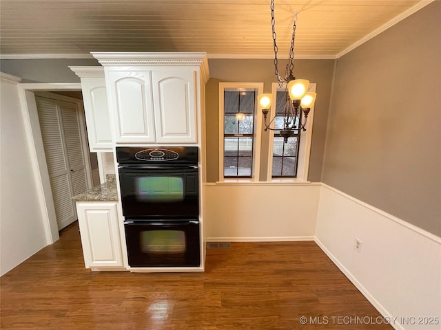 kitchen with dobule oven black, wood finished floors, white cabinetry, crown molding, and a chandelier