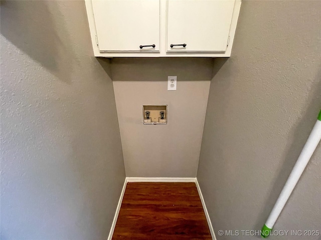 washroom with baseboards, cabinet space, washer hookup, and wood finished floors