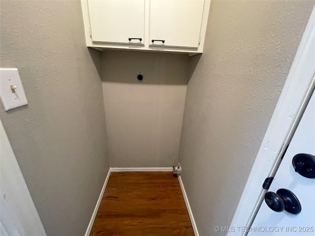 washroom featuring cabinet space, wood finished floors, and baseboards