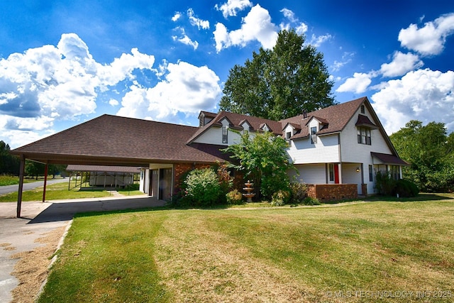 view of front of house featuring a carport, brick siding, a front lawn, and driveway