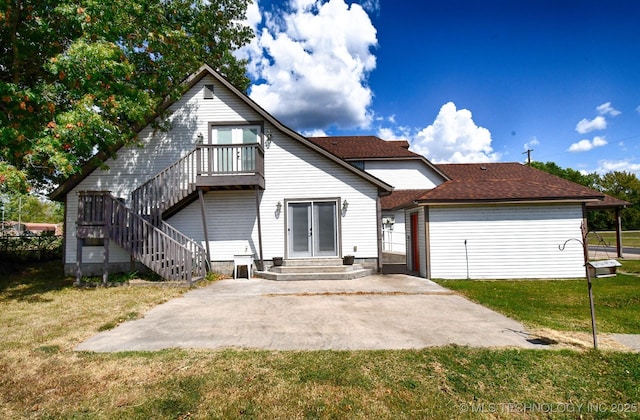 rear view of house featuring entry steps, a patio, stairway, and a lawn