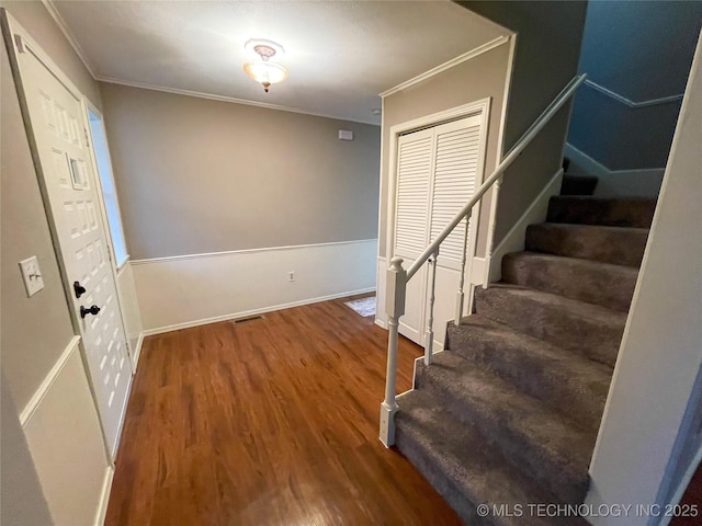 entryway featuring stairway, ornamental molding, baseboards, and wood finished floors