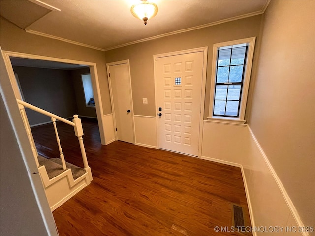 entryway with visible vents, baseboards, dark wood finished floors, and crown molding