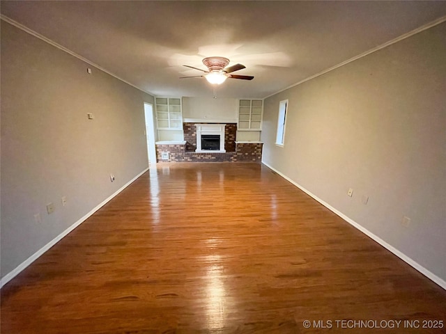 unfurnished living room featuring built in shelves, a ceiling fan, wood finished floors, a fireplace, and baseboards