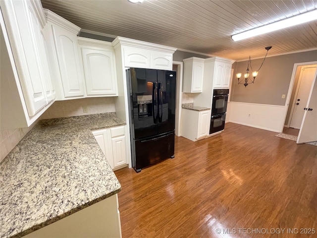 kitchen featuring black appliances, ornamental molding, wood finished floors, an inviting chandelier, and white cabinets