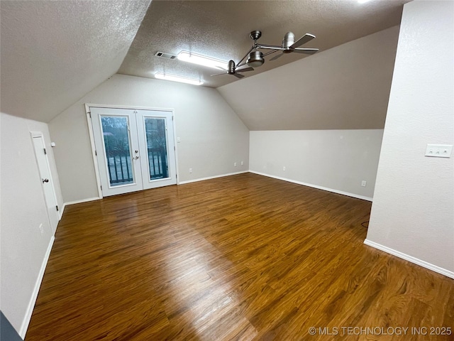 additional living space featuring visible vents, a textured ceiling, ceiling fan, and wood finished floors