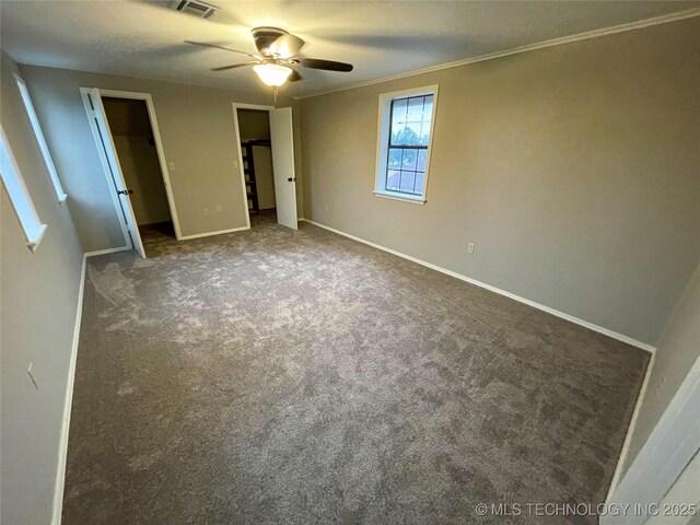 unfurnished bedroom with carpet, visible vents, baseboards, ceiling fan, and ornamental molding