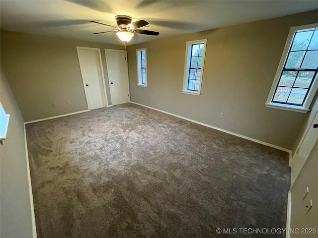 unfurnished bedroom with multiple windows, baseboards, and carpet