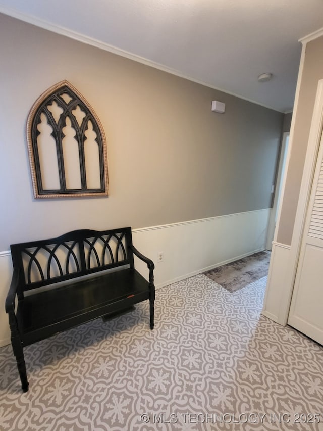 living area with crown molding and baseboards