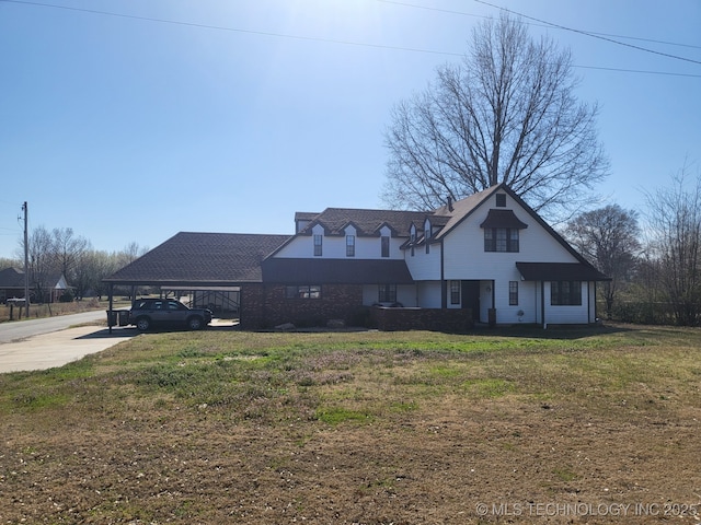 view of front facade featuring driveway, a carport, and a front lawn