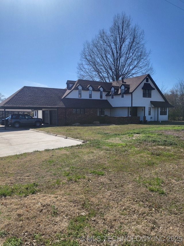 view of front of property featuring a carport, concrete driveway, and a front lawn