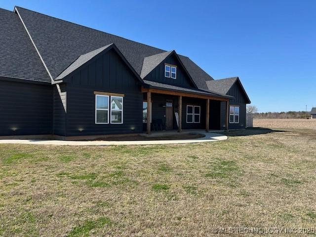 view of front of property featuring a patio, board and batten siding, and a front lawn