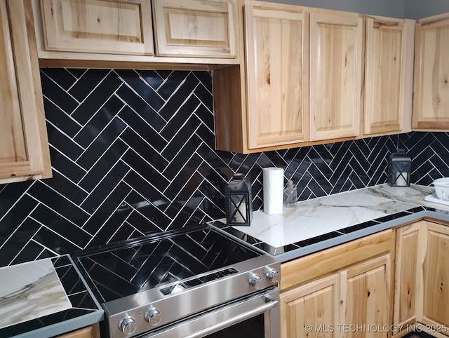 kitchen with light brown cabinetry, decorative backsplash, and stainless steel range with electric stovetop