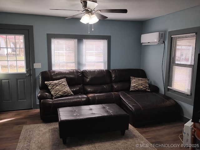 living area with a wall mounted AC, a ceiling fan, and wood finished floors