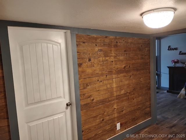 interior space with a textured ceiling and wood finished floors