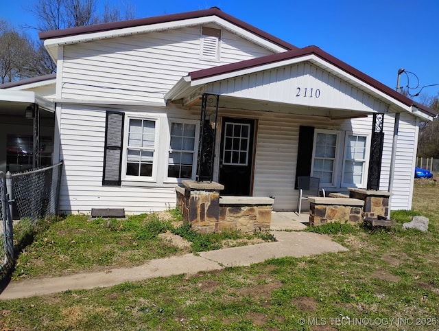 bungalow-style home featuring a porch and fence