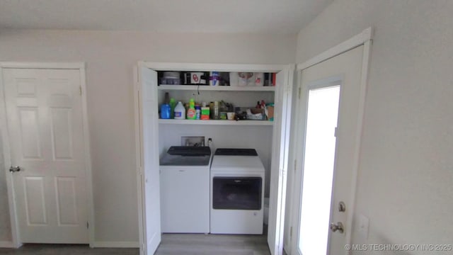 laundry area with washing machine and clothes dryer, laundry area, and wood finished floors