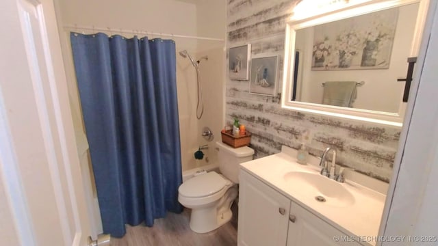 full bath with vanity, wood finished floors, wallpapered walls, shower / bath combination with curtain, and toilet