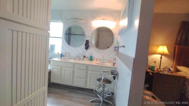 bathroom featuring a sink, wood finished floors, and double vanity