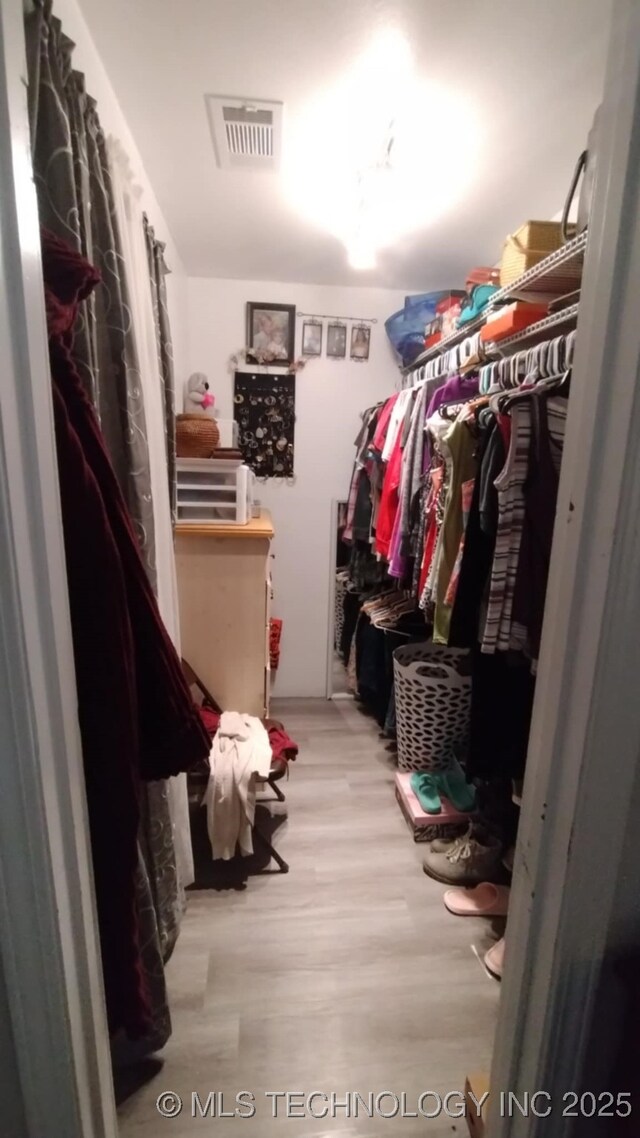 walk in closet featuring visible vents and wood finished floors