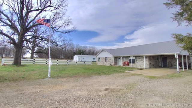 view of yard with a patio, an attached carport, driveway, and fence