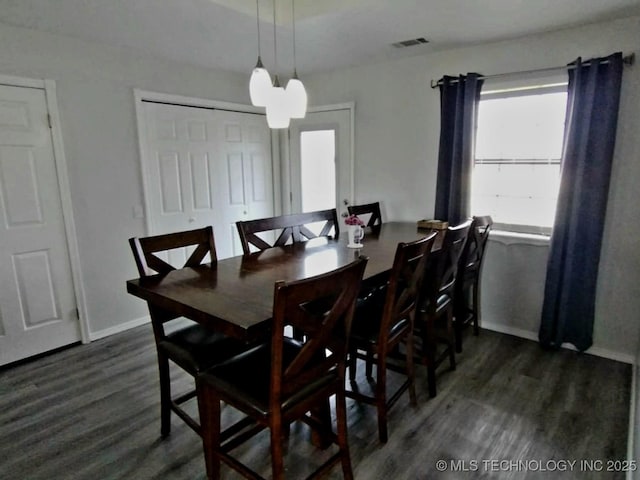 dining room featuring an inviting chandelier, dark wood-type flooring, baseboards, and visible vents