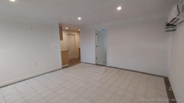 spare room with recessed lighting, a wall mounted AC, and baseboards