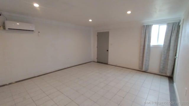 unfurnished room featuring an AC wall unit, recessed lighting, and baseboards