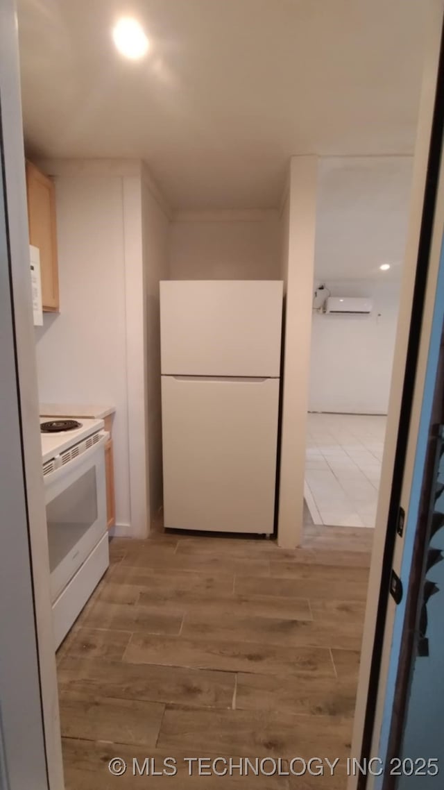 kitchen with light wood-type flooring, white appliances, light countertops, and a wall unit AC