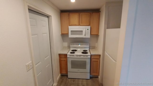 kitchen with recessed lighting, white appliances, wood finished floors, and light countertops