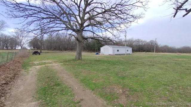 view of yard featuring an outbuilding, a rural view, and dirt driveway