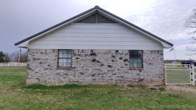 view of home's exterior with a lawn and fence