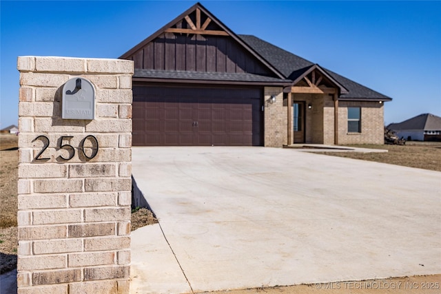 view of front of house with board and batten siding, concrete driveway, a garage, and a shingled roof