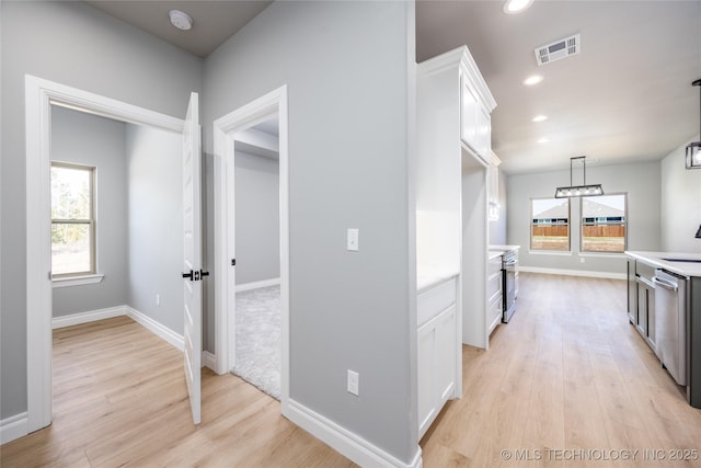 kitchen featuring visible vents, a healthy amount of sunlight, light countertops, and white cabinetry