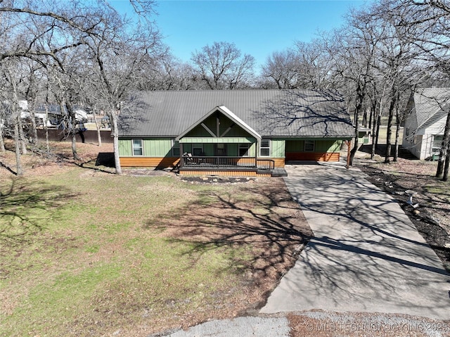 exterior space with a yard, a carport, covered porch, and concrete driveway