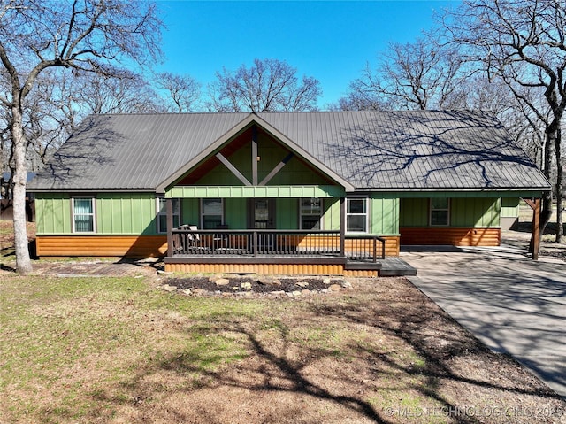 view of front of property with covered porch, driveway, board and batten siding, and an attached carport