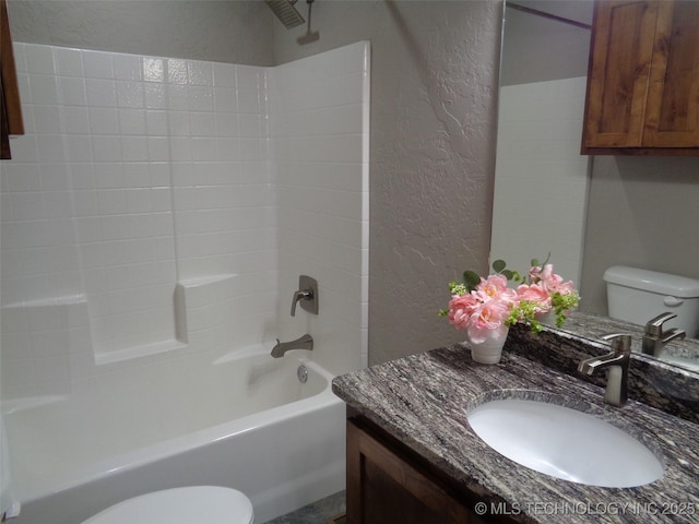 bathroom with vanity, toilet, a textured wall, and shower / bathtub combination