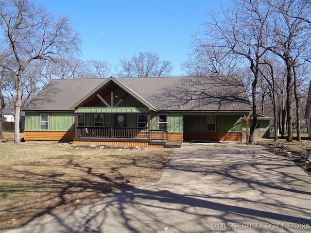 chalet / cabin featuring an attached carport, covered porch, and driveway