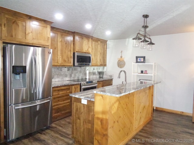 kitchen with dark wood-type flooring, light stone countertops, tasteful backsplash, and stainless steel appliances