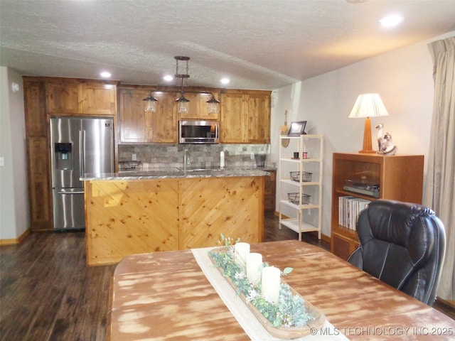 kitchen with a kitchen island, dark wood-type flooring, decorative backsplash, stainless steel appliances, and a textured ceiling