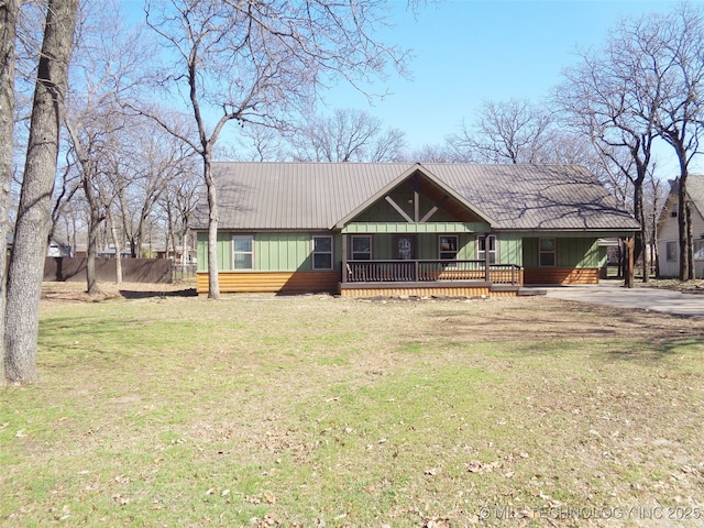 view of front of property featuring covered porch, driveway, and a front lawn