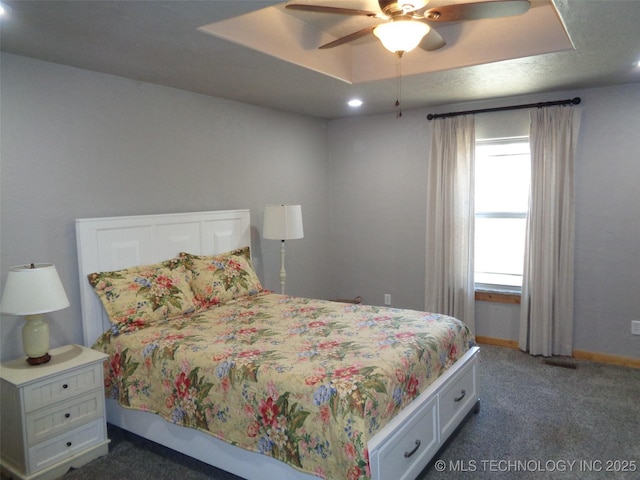 carpeted bedroom featuring recessed lighting, a tray ceiling, baseboards, and ceiling fan