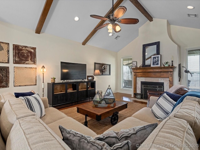 living area with visible vents, plenty of natural light, and wood finished floors