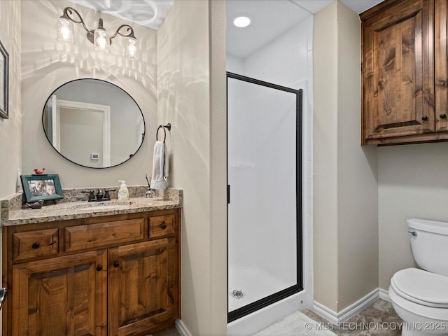 bathroom with vanity, toilet, baseboards, and a stall shower