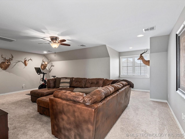 living room featuring baseboards, a ceiling fan, visible vents, and light carpet